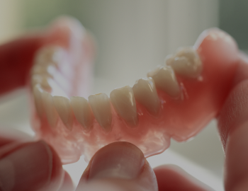 Dental technician holding a denture