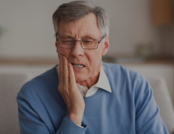 Elderly Man Having Toothache Touching Cheek Suffering From Pain Sitting On Sofa At Home