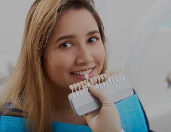 Pretty smiling young Asian woman having teeth whitening procedure