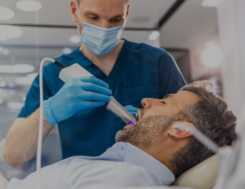 Young man patient having dental treatment at dentist's office